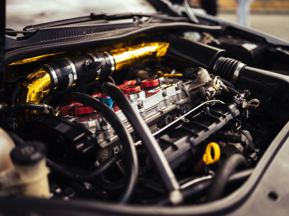 Getunter Motor mit goldenem Ansaugrohr und roten Zündspulen